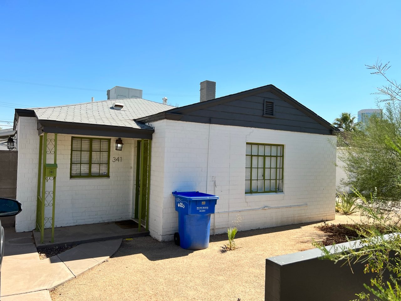 The home before painting, with dated lime-green trim and weathered brick