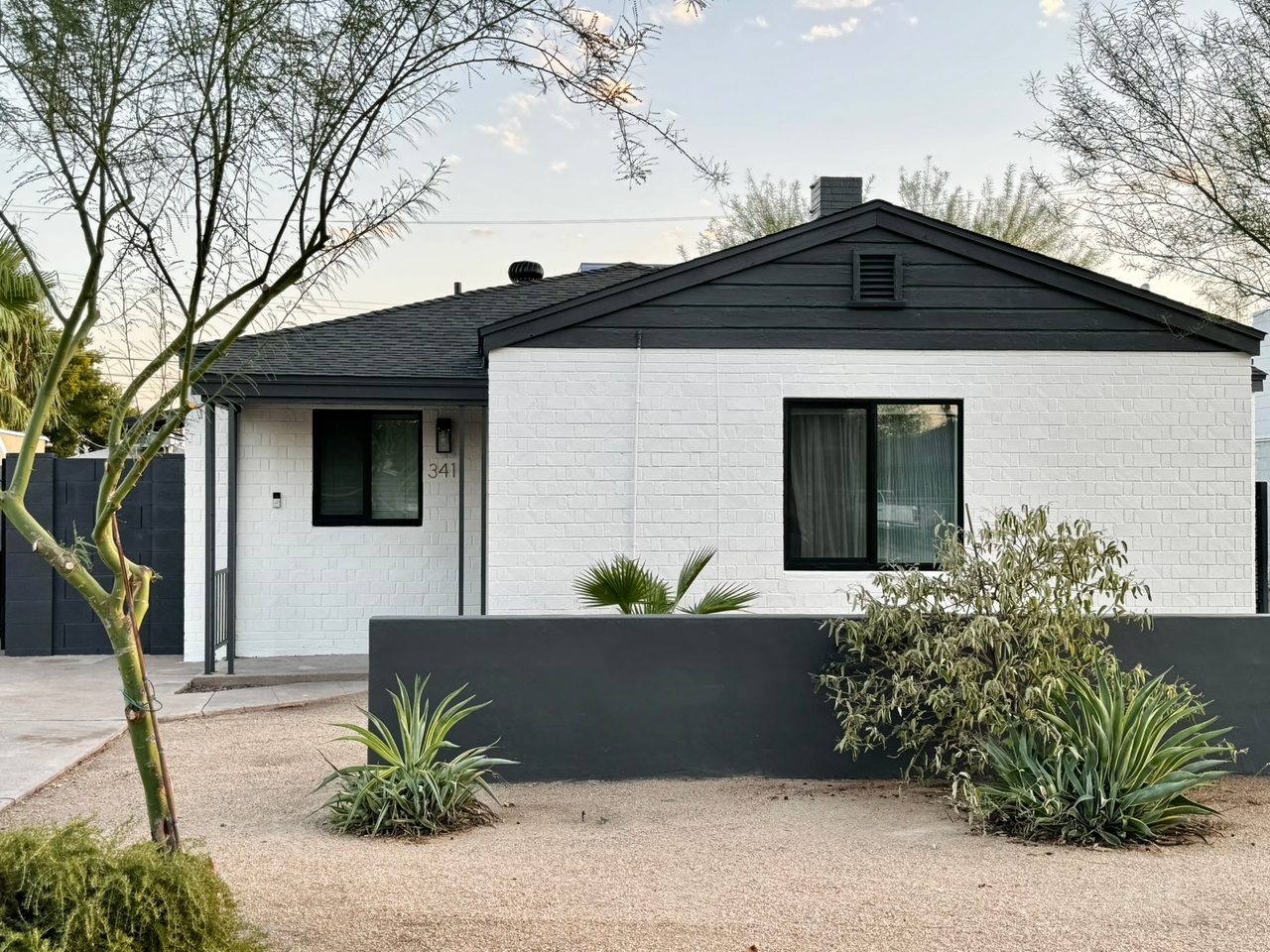 The same home after, in bright white brick with black trim